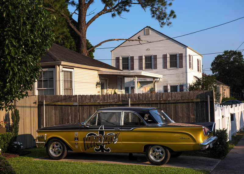 A photograph of a classic car painted in the Saints colors reading Who Dat in New Orleans. 
